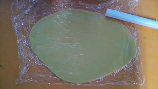 在桌面舖層保鮮膜將麵團放上再蓋一層保鮮膜在麵團上，用桿麵棍將麵團桿平約0.5公分；放入冷凍約50分。