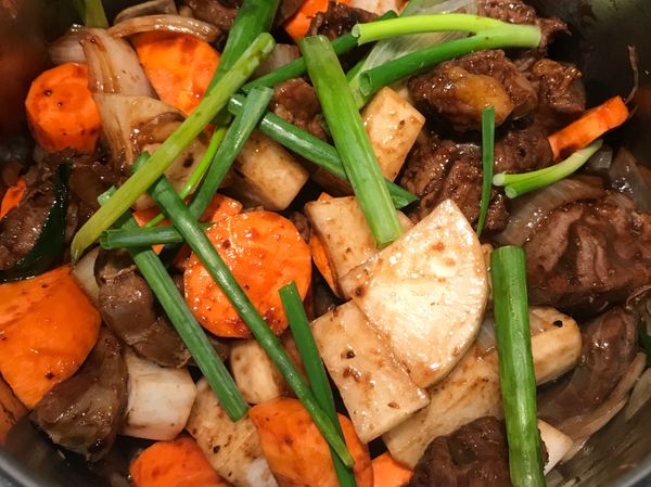 再加入紅蘿蔔、白蘿蔔、蔥段拌炒上色⋯