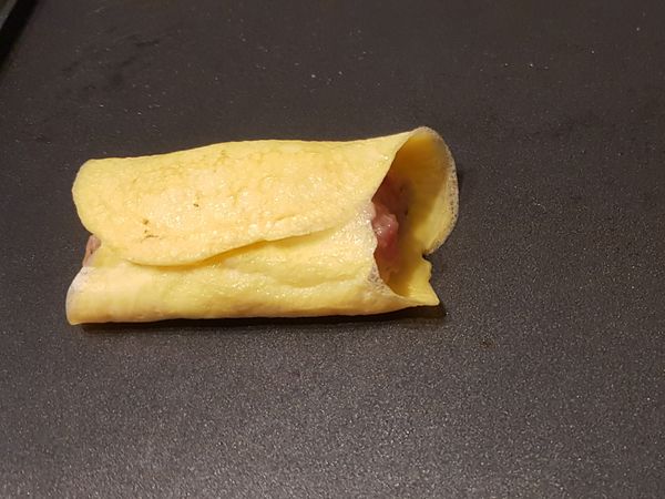 在蛋液八分熟前，捲起肉餡。