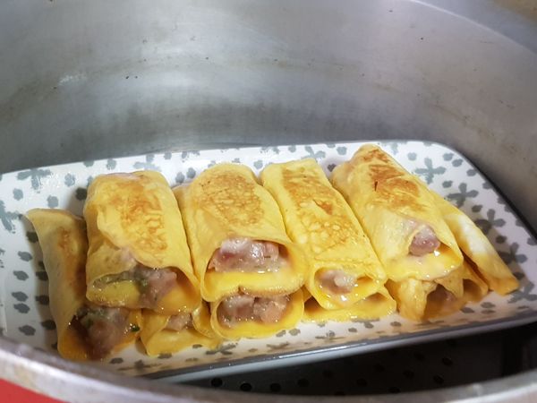 電鍋先放入一杯水，按下開關，待電鍋水蒸氣出，將蛋捲餃放入電鍋中，蒸12分鐘。蒸的時候，鍋蓋要用一根筷子留縫，不可全蓋。