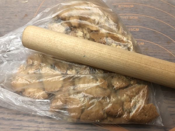 餅乾裝入塑膠袋中，用桿麵棍壓至細碎狀。
