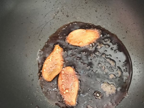 爆香薑片，薑片表面有起泡後，再將雞塊下去炒（2-3分），再倒入米酒半瓶。