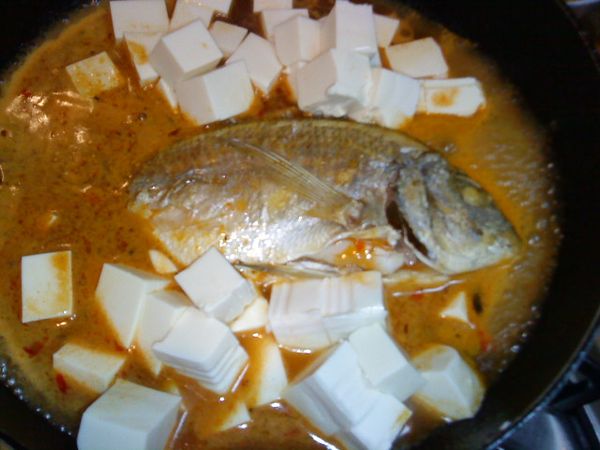 加入[開水]點火燒開湯汁，加入豆腐蓋上鍋蓋悶煮2分鐘