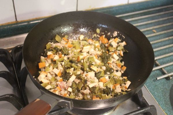 將酸菜也入鍋翻炒。