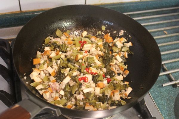 最後加入辣椒、胡椒、香油、醬油、砂糖及白醋炒勻，視情況添鹽調味，並淋上米酒，攪拌一下。