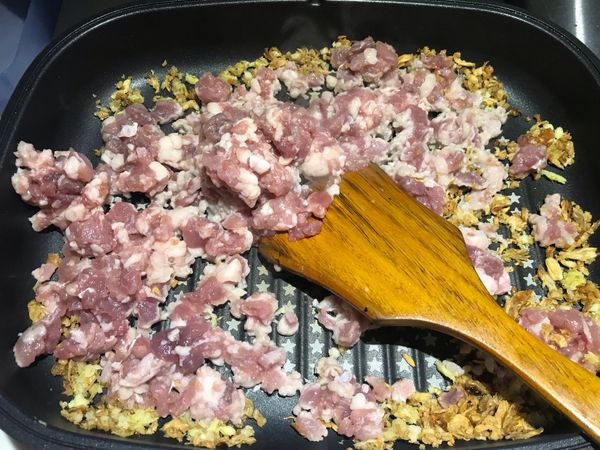 將蒜頭。薑都切成末。
起油鍋。油量只需要5元硬幣大小就好。一點點就可以了。因為豬肉炒一炒會釋出豬油，這樣最後會很多油，所以暴香的油放一點點就好。免得太油了。
放入蒜末。薑末。油蔥酥。爆香拌炒一下。
（吃辣者：可以切辣椒末下去炒）
再放入豬絞肉⋯中火拌炒。