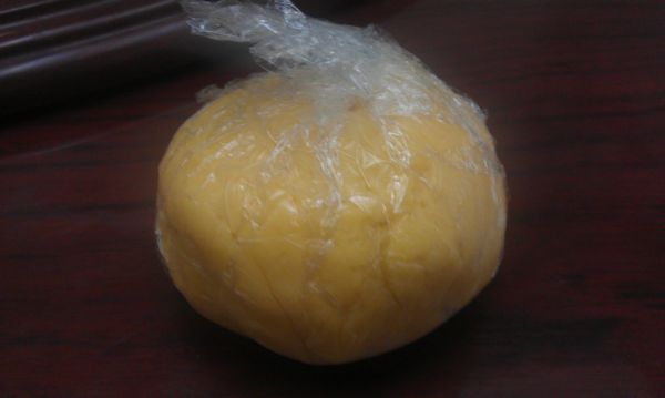 將[派皮]材料均勻混合：室溫下軟化的奶油與糖粉混合後，加入蛋黃拌勻，加入過篩的粉類及牛奶，用刮刀混合成團狀，用保鮮膜包起，放入冰箱冷藏30分鐘。