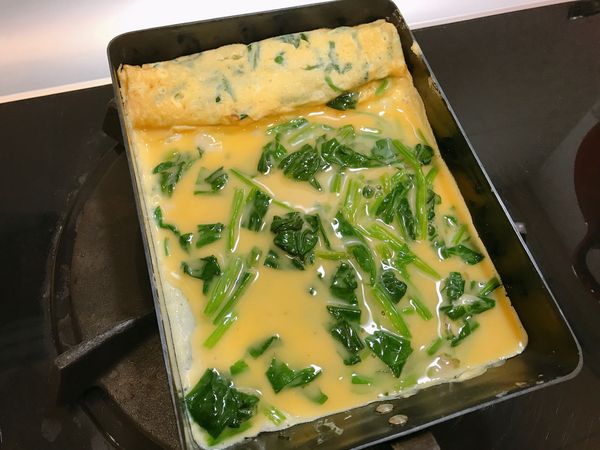 玉子燒鍋擦上一層油，開中小火，鍋熱後倒入1/3蛋液，待表面半凝固後捲起，用鍋鏟將蛋推至前方，並用鏟子稍微抬起再倒入1/3蛋液，待表面半凝固後捲起，重複至蛋液用完