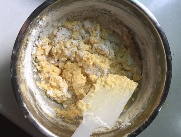 倒入麵粉及泡打粉,用軟刮刀切拌至無乾粉（切勿攪拌過度）。
（照片上是還有乾粉的狀態）
