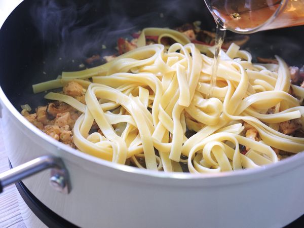 放入麵條並加入少許的煮麵水和香菇水，火力轉至90檔收汁