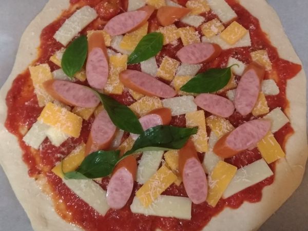 依喜好加上肉類及切片番茄即可進烤箱，210度烤12~15分鐘即可出爐，再鋪上羅勒葉完成。