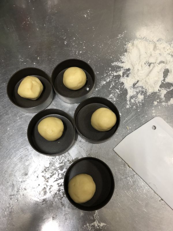 再將鬆弛完成的麵團分割成每個35g，入模後先大概壓平，再用大拇哥擠底部角角，邊順時針旋轉邊把麵團推擠上來