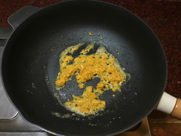 倒適量油,放入鹹蛋黃拌炒,炒出有泡沫