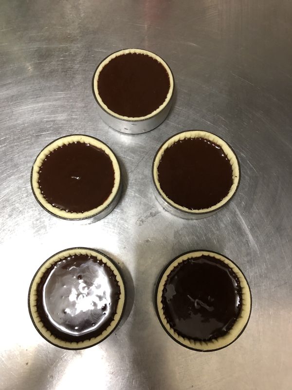 烘烤及組合
將巧克力奶油糊填入半熟的塔殼內，儘量填到表面張力的狀態會比較漂亮，就像最上方那個烙單的塔美，看起來像吃了漂漂拳