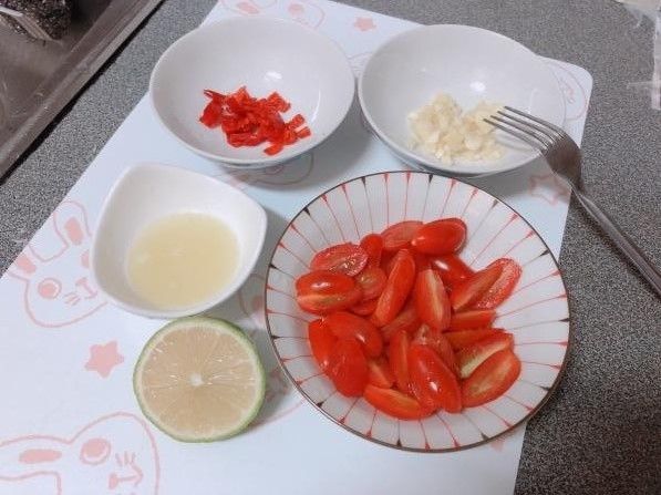 食材清洗後，小番茄對半切，大蒜切丁，小辣椒切小片備用。