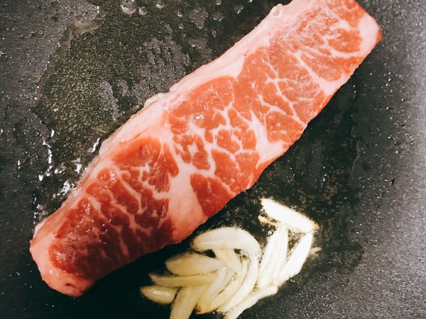 熱油鍋
先加入蒜片去炸
再加入牛排進去
（從油花多的地方開始煎，逼出香氣跟牛油更香喔）