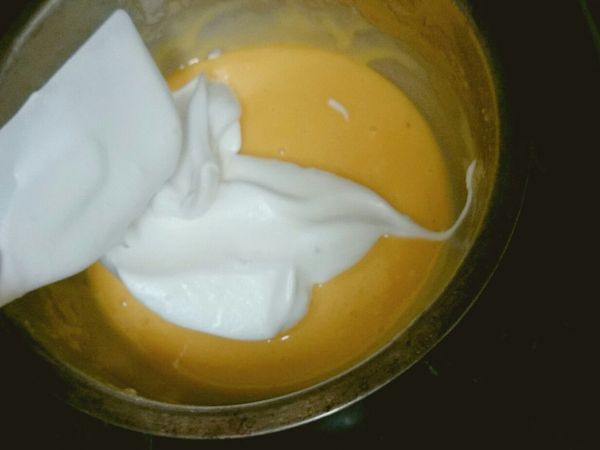 3分之1蛋白加入蛋黃糊拌勻，然後倒回蛋白霜裡輕拌均勻倒入鋪紙的烤盤，入爐輕敲一次，烤10分掉頭10分