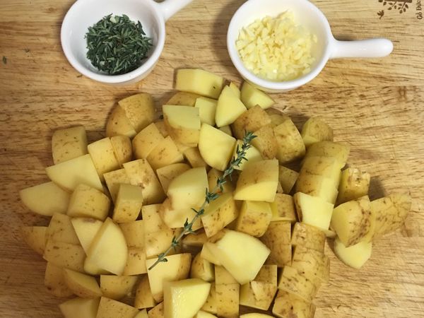 將蒜頭去皮切末；將百里香葉子從梗上取下來；馬鈴薯切大姆指指甲大小的丁狀；