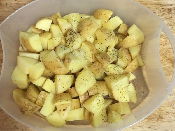 在切好的馬鈴薯上放半匙鹽和少許黑胡椒粉及少許橄欖油拌勻，微波5分鐘（也可以蒸15分鐘）；