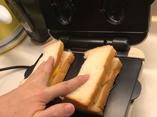 同時放入烤盤並用手壓一下，蓋上烤盤
也可以先將吐司事先切成兩半