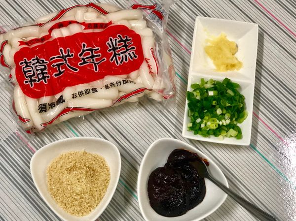 年糕用水浸泡著，蔥切細蔥花，蒜磨泥