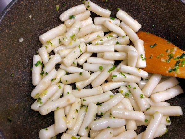 年糕撈出放入鍋中，跟蔥花拌均勻，鋪平20秒在拌一下直到年糕變軟外表有淡淡黃黃的（過程都是小火）