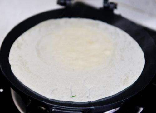 电饼铛烧热，倒入面浆，用刮板刮匀；