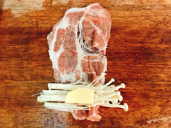 2. 豬肉片攤平後，放上金針菇、起司。