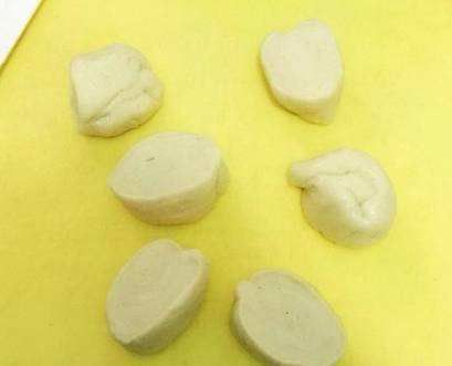 将面团从中切块一分为二，搓成长条的面剂子，切成一个个的小面团，和包饺子差不多；