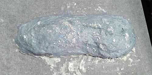 烤盤上灑些高粉當手粉，將發酵好的麵糰直接倒在烤盤上，再灑些高粉，用手整形成長橢圓狀