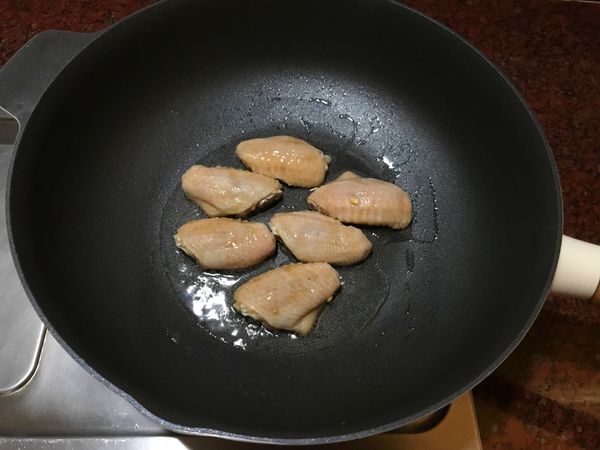 熱鍋倒油,放入雞翅,用小火煎