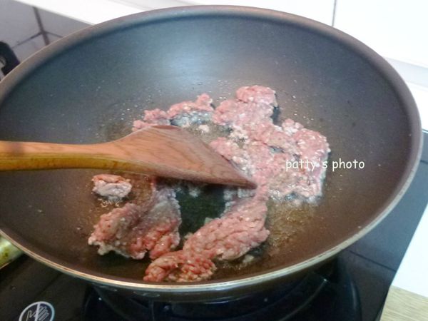 放入牛絞肉大火拌炒至表面變白，轉中火。