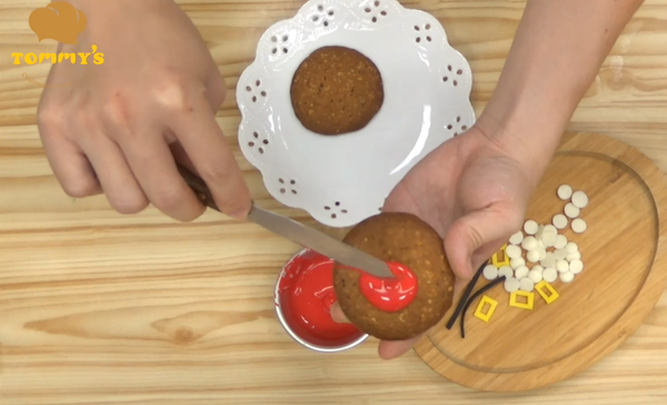 帶餅乾冷卻後，在餅乾上層塗上紅色巧克力