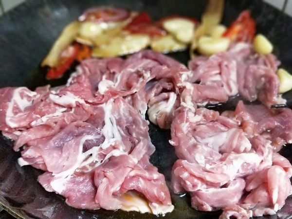 豬肉片放入鍋中，加辣椒，用中小火翻炒，至肉片略轉白。