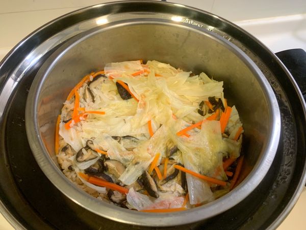 取電鍋內鍋放入白米、蝦皮、高麗菜絲、紅蘿蔔絲、乾香菇絲，加2杯水(含泡香菇的水)，加入小磨坊蔥風味油、醬油，烹大師稍微攪拌一下，放入電鍋，外鍋放一杯水，按下開關，開關跳起就完成了