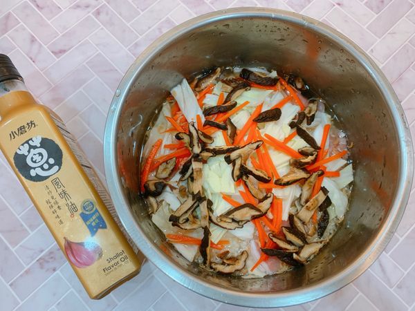 白米洗淨瀝乾、乾香菇泡軟切絲、高麗菜順紋路切成易入口的粗絲、紅蘿蔔削皮切絲備用。泡香菇的水可以留下
