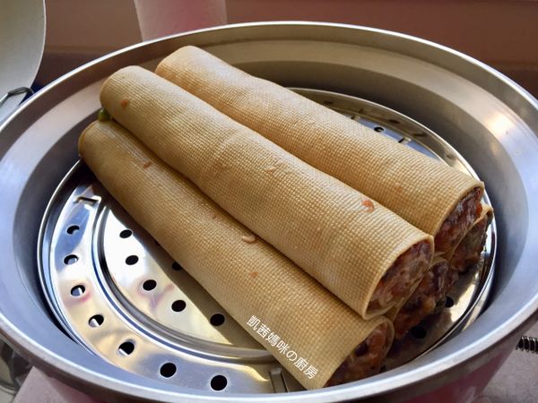 豆腐皮肉捲放蒸盤，電鍋外鍋加水1又1/2杯水蒸煮；電鍋開關跳起後，繼續燜10分鐘，確保完全熟透。