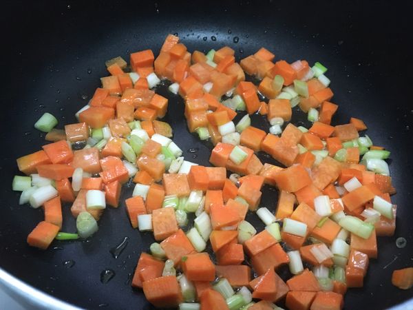 起油鍋，紅蘿蔔和蔥白先下鍋炒，炒至紅蘿蔔半熟。