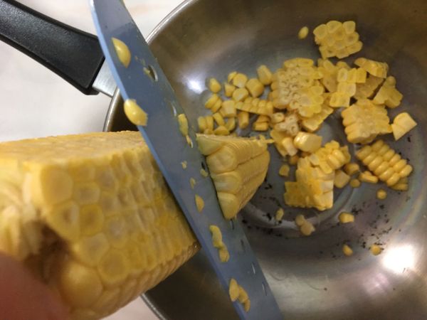 取一淺盆，玉米放上面削，就不會噴的到處是玉米粒啦👍