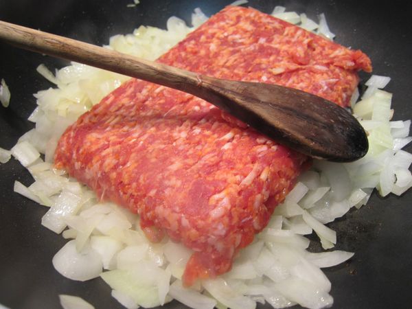 加入肉一起炒。如果買的到這一種帶點辣的義大利熱狗肉最棒! 如果不能，用瘦牛繳肉，或豬都可以，但在炒肉時要自己調味，加點鹽