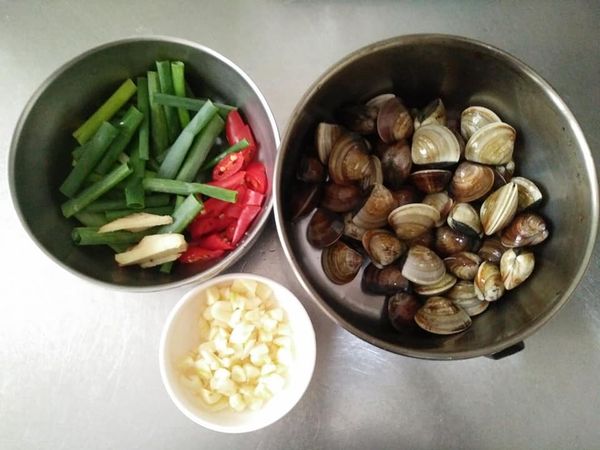 蛤蜊先加入塩巴，並以400cc冷水蓋過蛤蜊，吐沙約3-5小時後，約1-2小時，需換水清洗再重泡吐沙至清水洗淨時吐沙時，水無泥沙、雜質即可，蒜頭敲碎、青蔥切段、辣椒斜切、薑切絲，備用；
