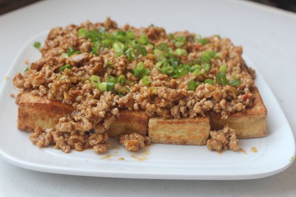 將肉醬淋在豆腐上，灑上蔥花，就可上桌。臭豆腐外酥內軟，麻婆肉醬味醇微辣，醬汁滲入豆腐，香上加香，一整個好吃極了。
