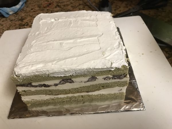 打發80g的動物性鮮奶油，這次要完全打發，抹在蛋糕表面。打發的鮮奶油，留下一些，用作裝飾水果的黏著劑。蛋糕可放在方形的成品盤上，或用厚紙板裁成適量大小，包上錫紙。