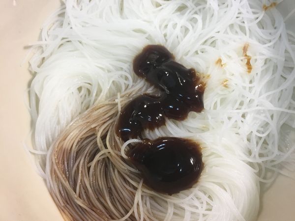 碗中放入泡軟的米粉加入蠔油1匙、黑龍蔭油1匙、香油半匙、白胡椒粉、少許香菇水攪拌均勻