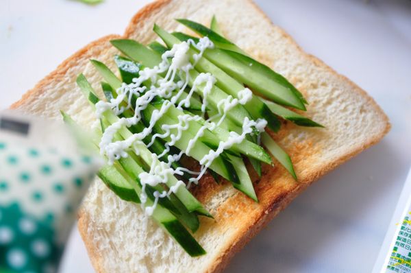 準備三明治，鋪上小黃瓜絲後再幾些沙拉