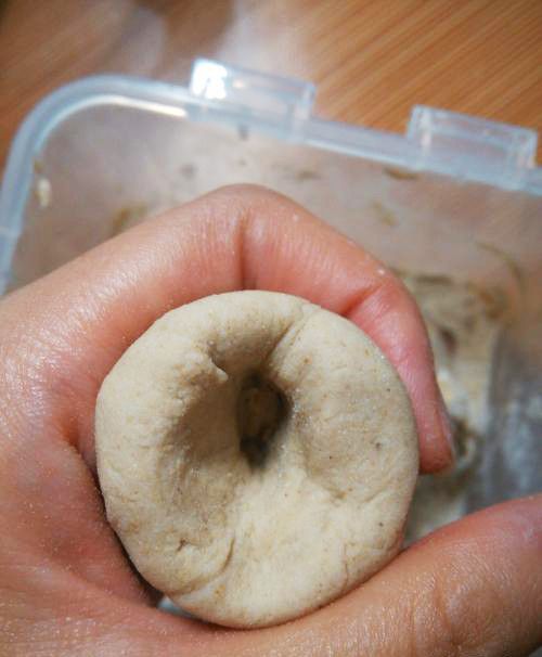 将醒发好的面团分成若干等份，并搓成圆球，用大拇指顶住面团的中间转圈，形成中间是空的窝头状；