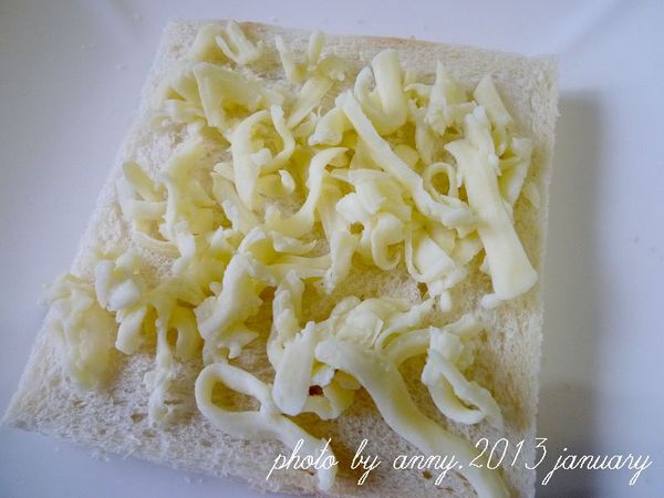 三片土司放上適量的焗烤乳酪絲，入烤箱用150度烤約8分鐘(依個人烤箱而定)至乳酪絲融化~