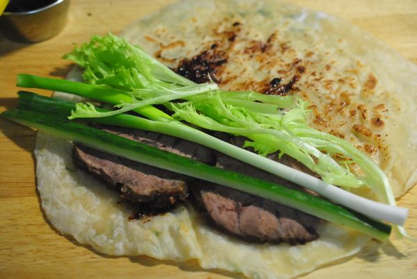 麵皮擦上一層甜麵醬,擺入牛肉,蔥,小黃瓜及少許生菜,捲起,切適口大小.