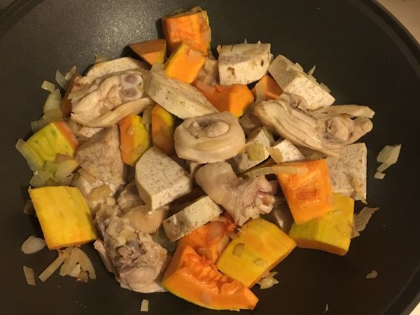 放油將洋蔥炒出香味，依序加入南瓜及芋頭，將雞腿肉川燙後加入拌炒，炒香後加水淹蓋食材，等水滾後加入切碎的咖哩塊，食材悶煮熟後即可關火