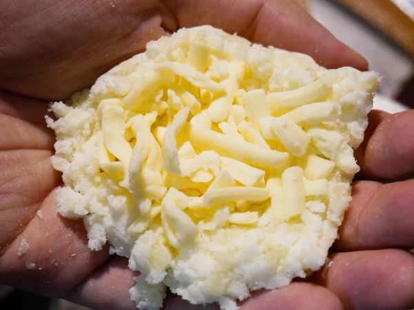 將混合好的馬鈴薯團取一些捏成掌心大，然後放上起司後，包起來。